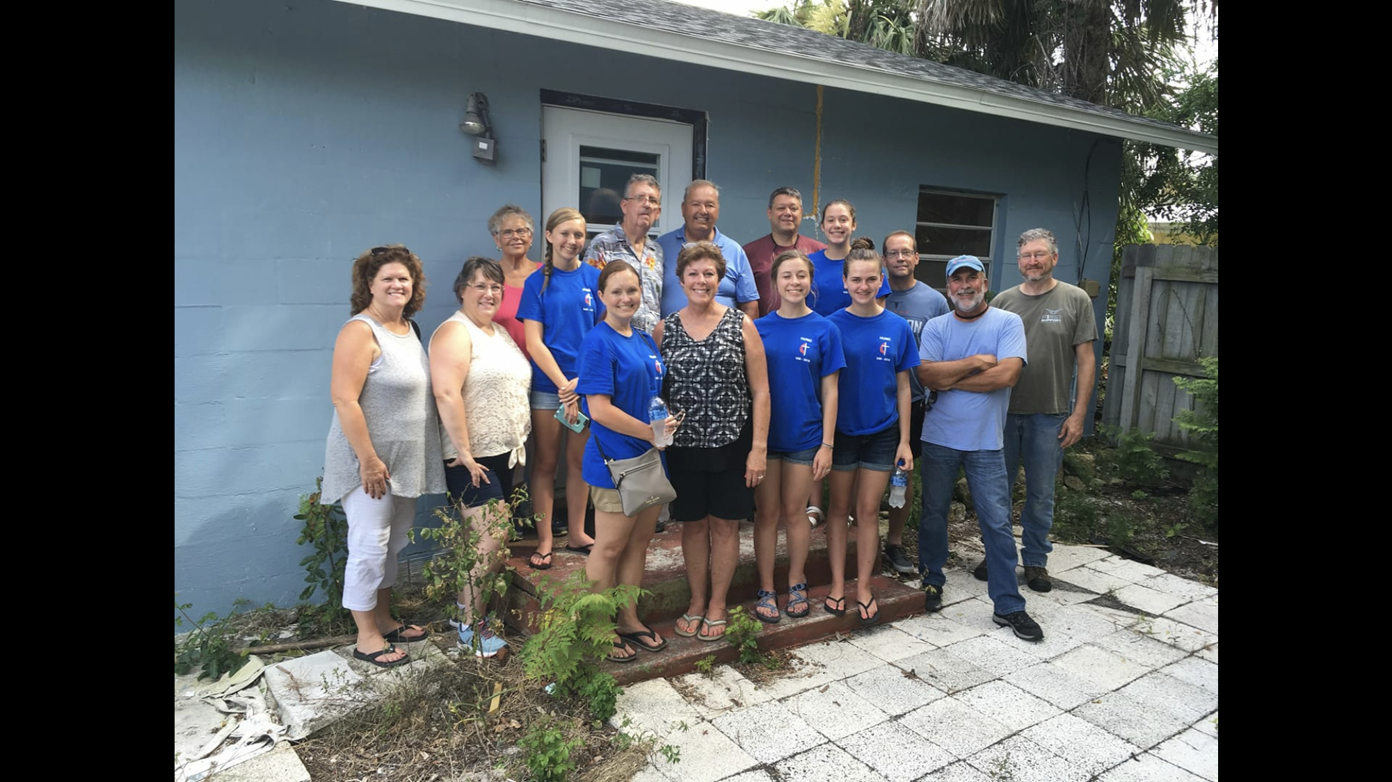 Voices for Valor founder Doug Canter with a youth mission team in front of a home they repaired